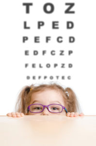 Funny girl in eyeglasses with eye chart behind